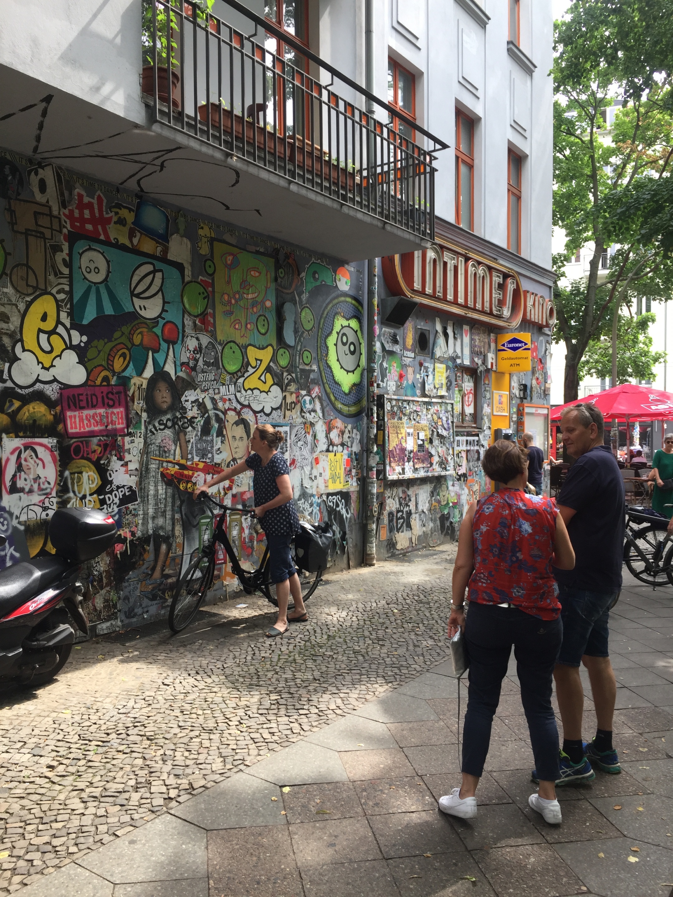 2 Personen schauen sich die Grafittis an der Wand des Kino INtimes an