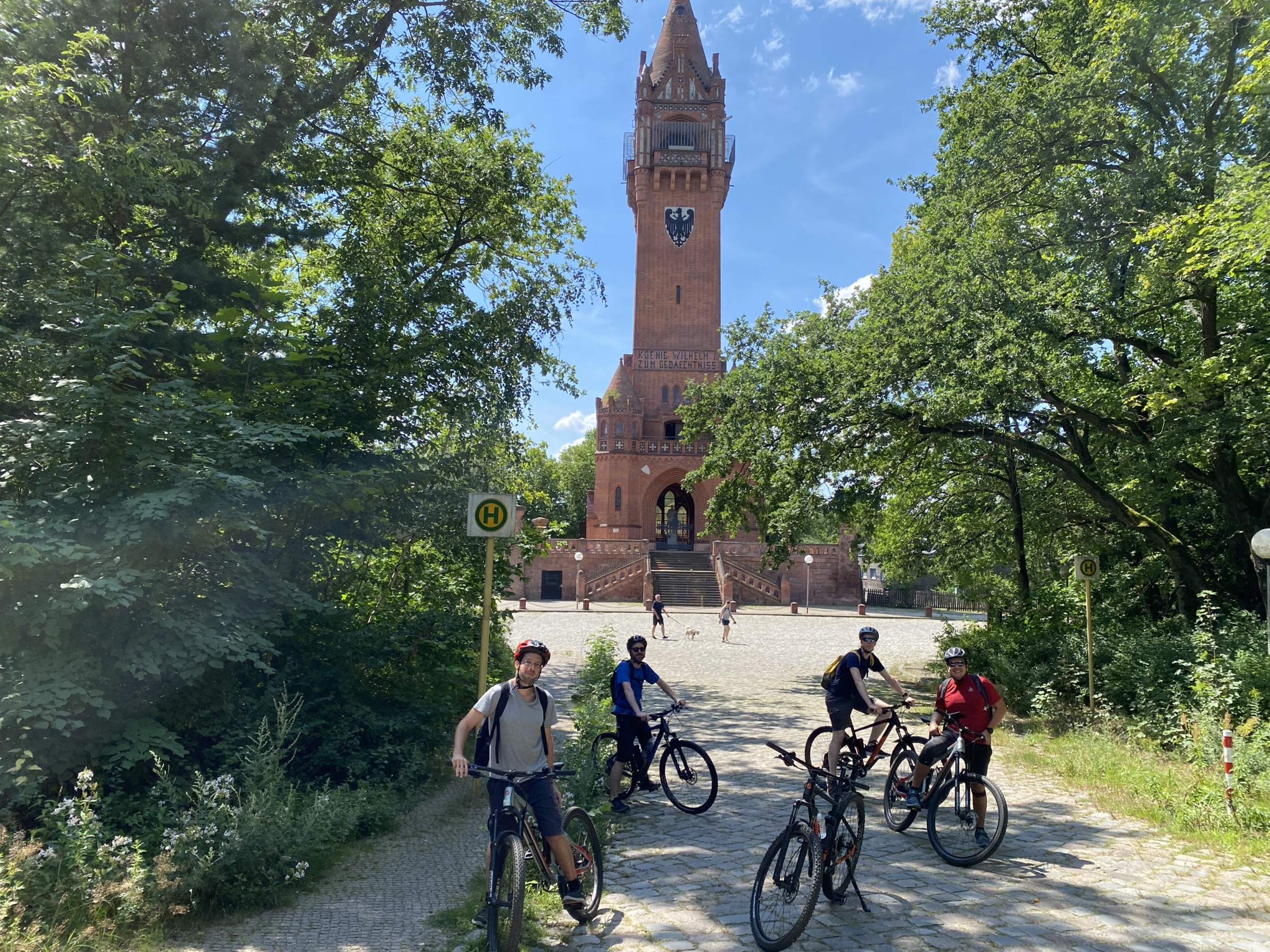 Eine Fahrradtruppe steht mit ihren Rädern vor dem Grunewaldturm